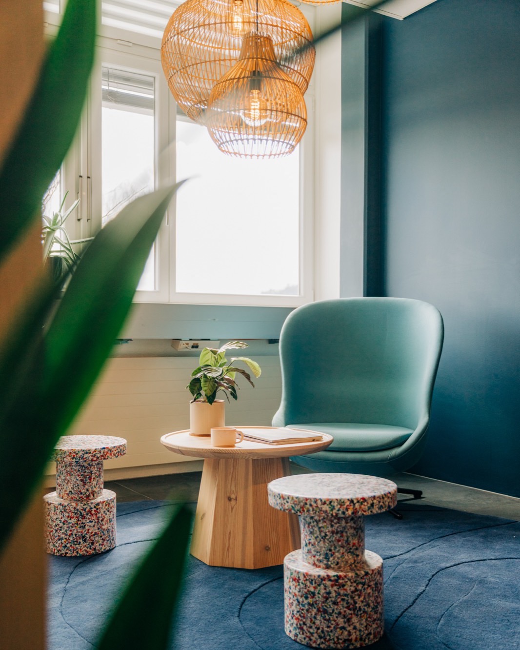 Lounge im Workspace Dorfmatte mit Sessel, Holztisch und Rattanleuchten